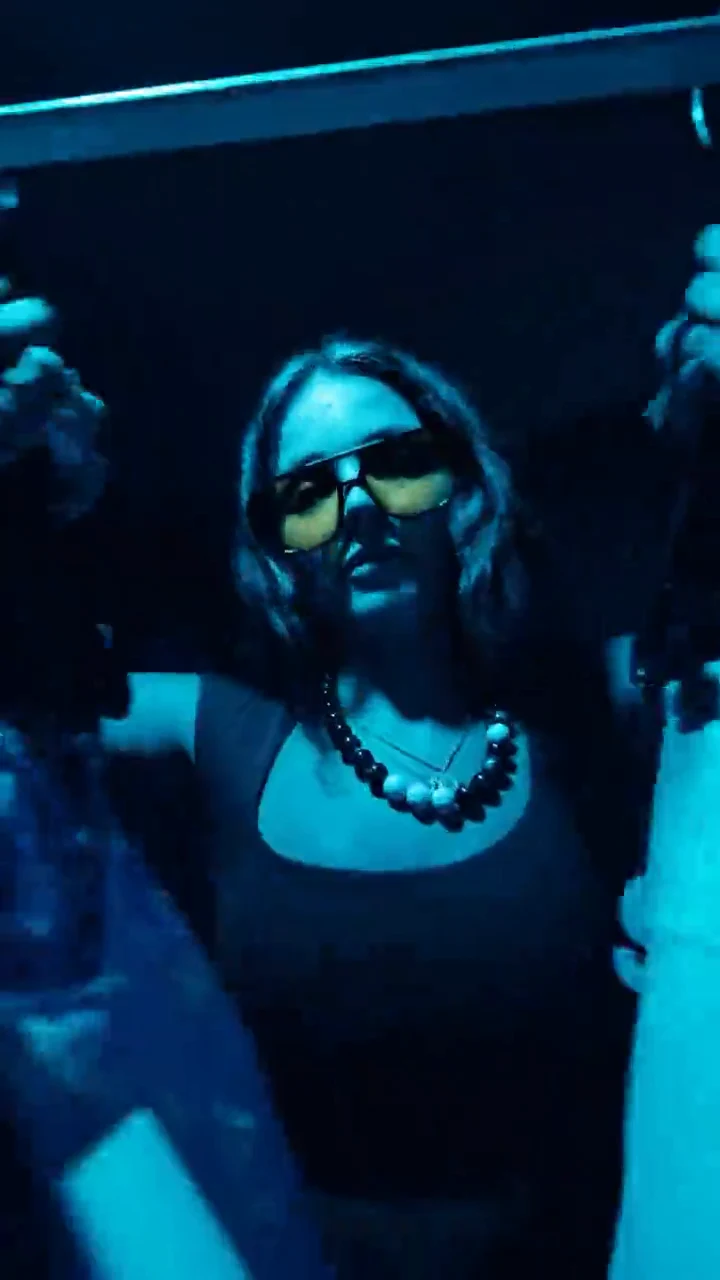 Creator with arms raised under blue lights during a Creator House UGC brand shoot